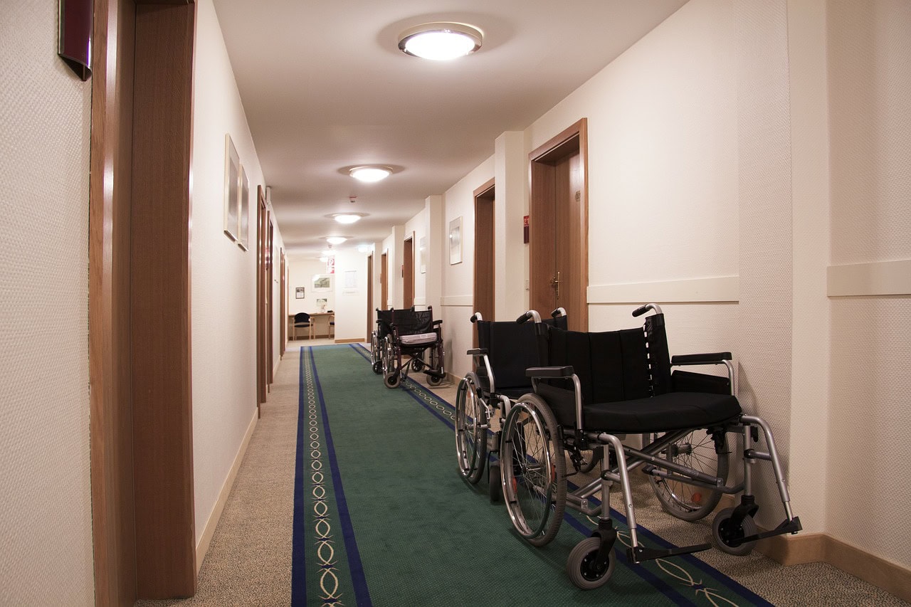 Eine Reihe von Rollstühlen im Flur einer Pflegeeinrichtung.
