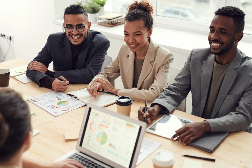 Arbeitende sitzen an einem Tisch und tauschen sich aus