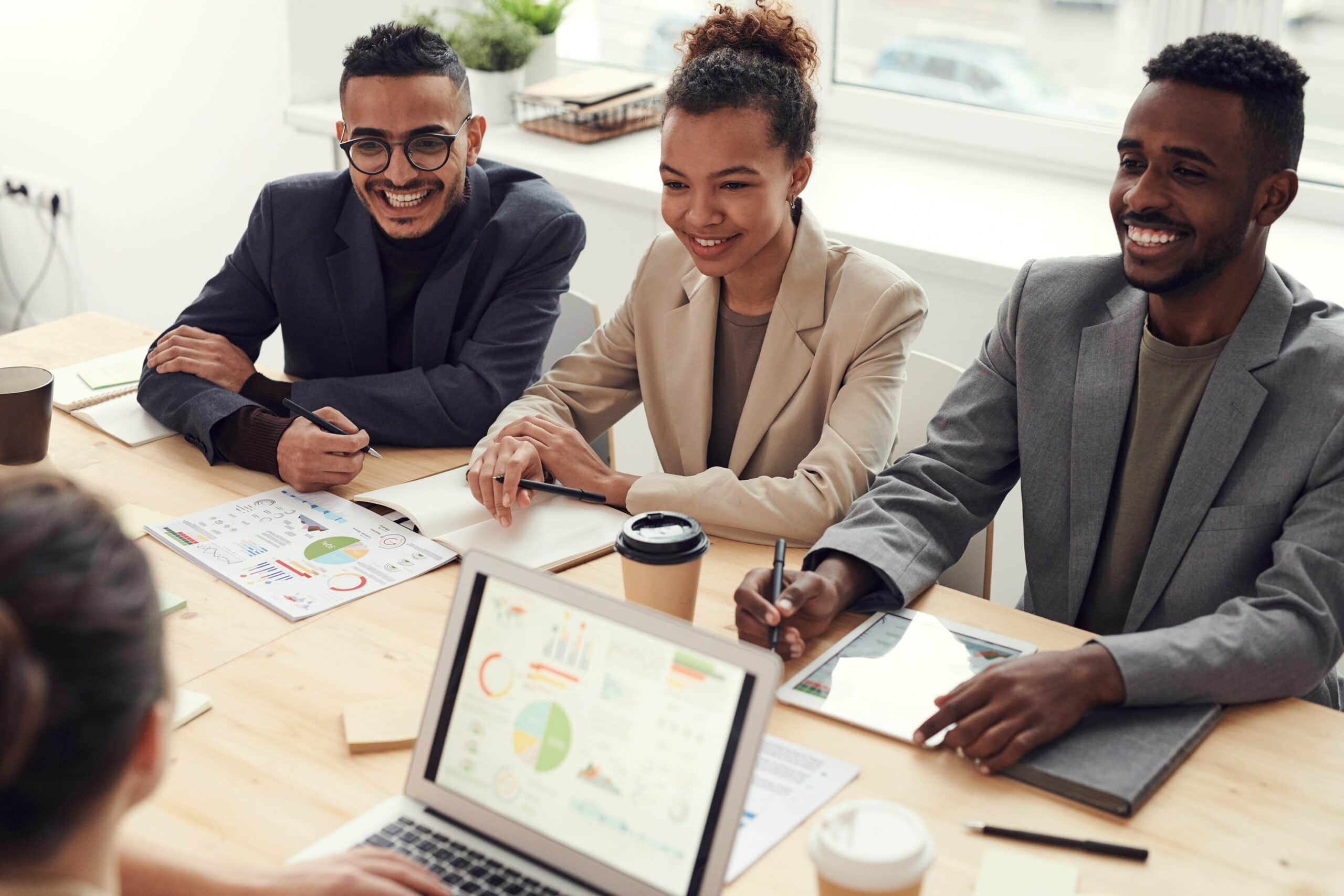 Arbeitende sitzen an einem Tisch und tauschen sich aus