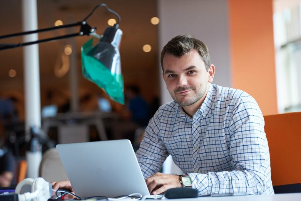Mitarbeiter eines Unternehmens sitzt vor einem Laptop